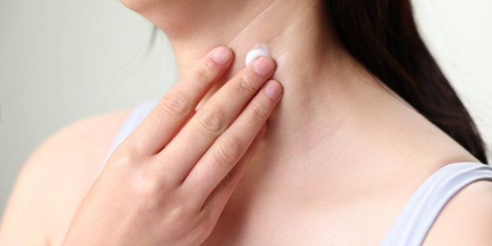 woman applying lifting cream, lotion on her neck with neck wrink
