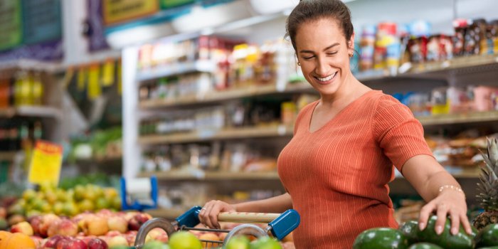 consumer evaluates quality of avocado in supermarket
