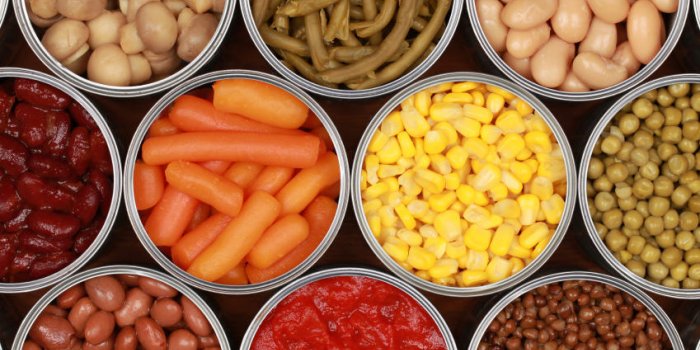 différents types de légumes comme le maïs, les pois et les tomates en conserve