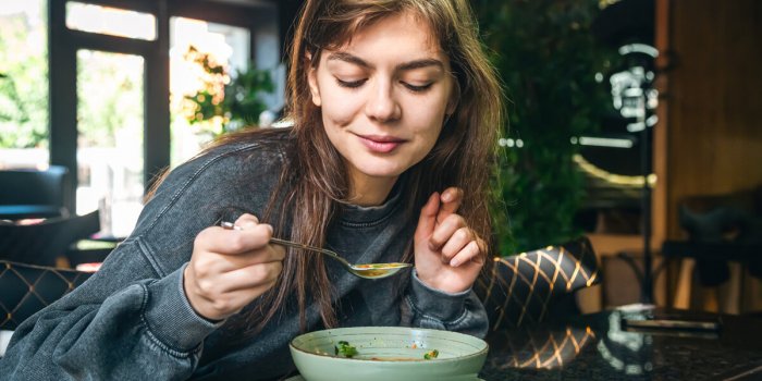 attractive woman eating vegetable soup in a cafe, healthy eating, veganism and vegetarianism, copy space