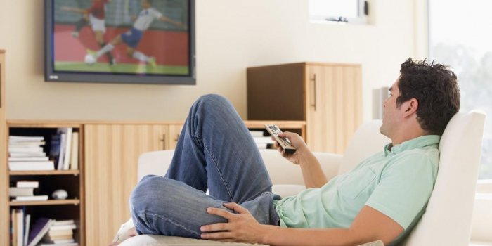 man in living room watching television