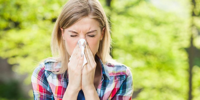femme avec des symptômes d'allergie nez soufflant