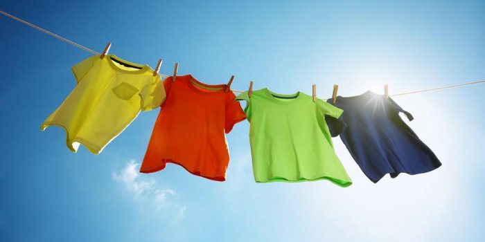 t-shirts hanging on a clothesline in front of blue sky and sun