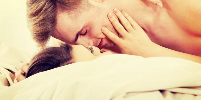 jeune couple caucasien s'embrasser sur le lit
