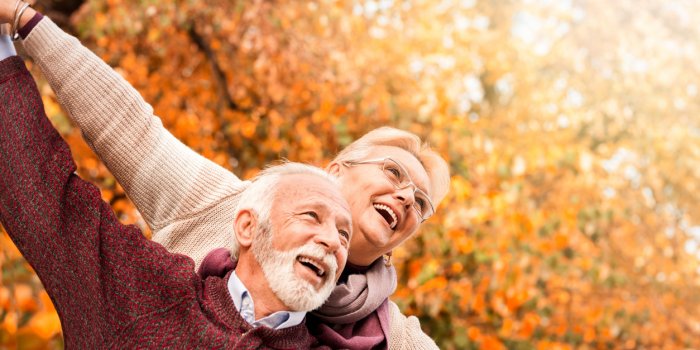 happy senior couple with outstretched arms enjoying retirement flying