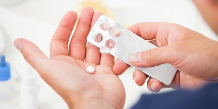 cropped image of man taking pill out from blister pack at home