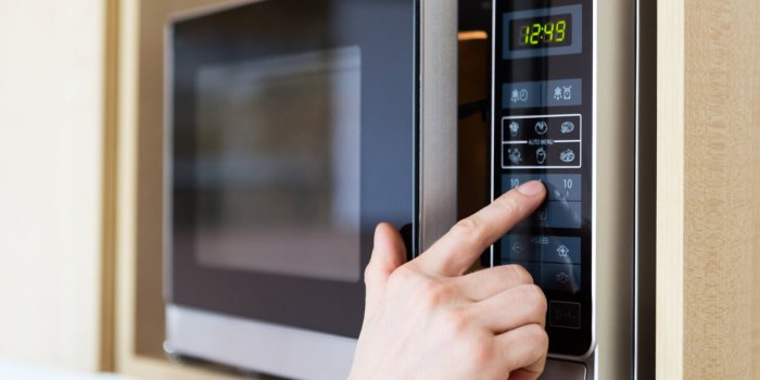 detail of male hand while using the microwave
