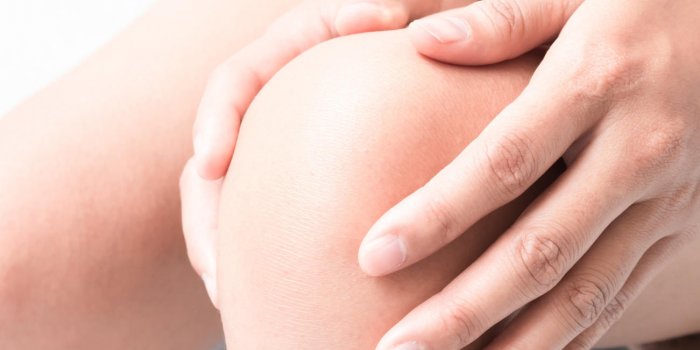 main de femme closeup tenir genou avec symptôme de la douleur, concept de soins de santé et de la médecine