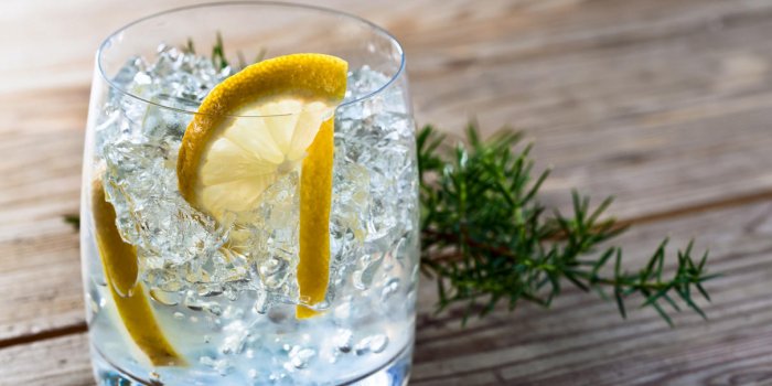 boisson alcoolisée avec du citron et de la glace sur une vieille table en bois