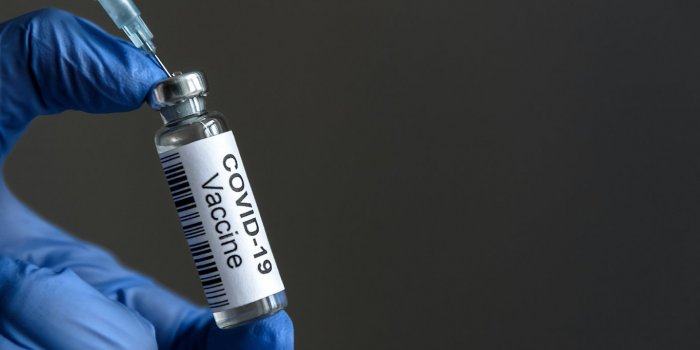 covid-19 vaccine bottle and syringe for coronavirus cure in doctor’s hand for background concept of corona virus treatm...