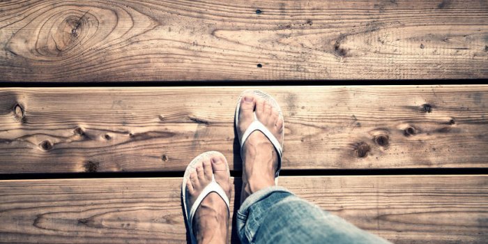 une femme marchant sur un plancher en bois, point de vue perspective une femme avec des tongs blanches et jeans marchant ...
