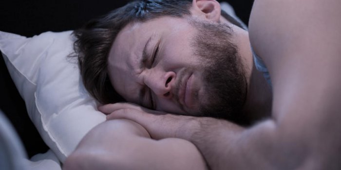portrait de jeune homme endormi ayant des cauchemars