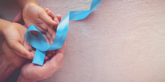 adult and child hands holding light blue, sky blue ribbons, toning background, prostate cancer awareness and adrenocortic...