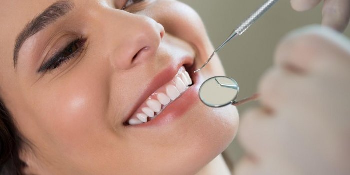 gros plan du dentiste examinant les dents de la jeune femme