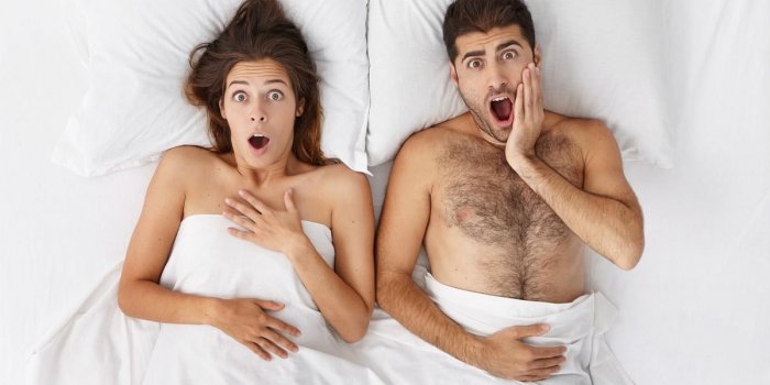funny emotional couple in bed screaming in shock while being late for work or flight, having terrified looks and opening ...