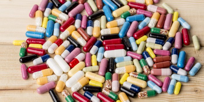 tas de médicaments colorés et pilules sur fond en bois
