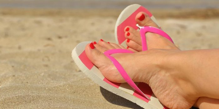 pieds de womans avec des tongs sur le sable