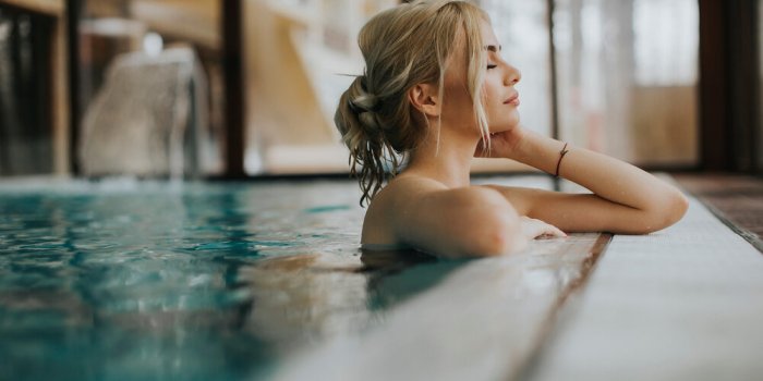 sensual young woman relaxing in spa swimming pool