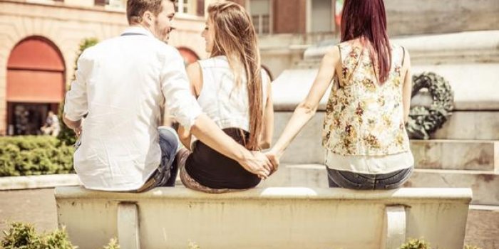 homme trompant sa petite amie au parc, il donne la main à la jeune fille assise à côté de sa petite amie image concep...