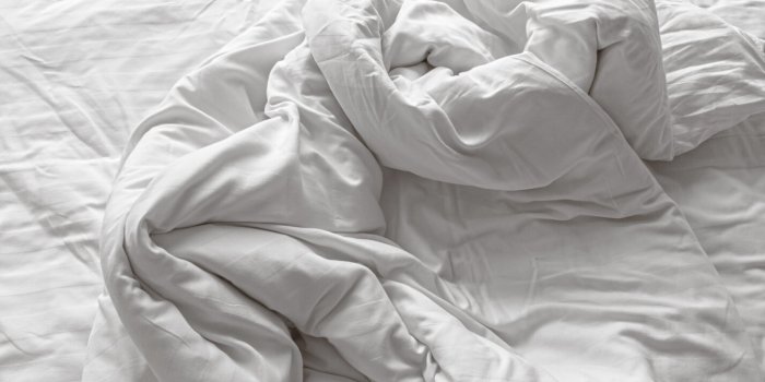 close-up view of disheveled and wrinkled white soft linen blanket
