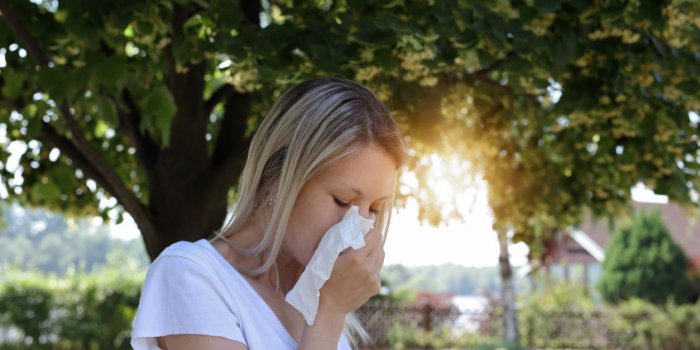 femme allergie au pollen éternuer dans un tissu à l'extérieur