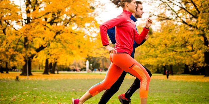 young couple jogging together in park - rear view