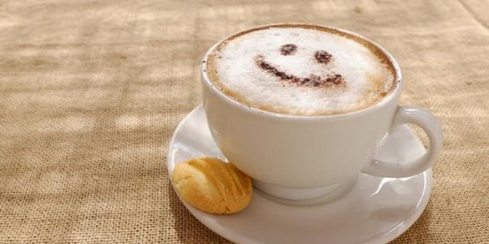café cappuccino avec de la mousse ou du chocolat souriant bienvenue visage heureux au restaurant ou à l'hôtel