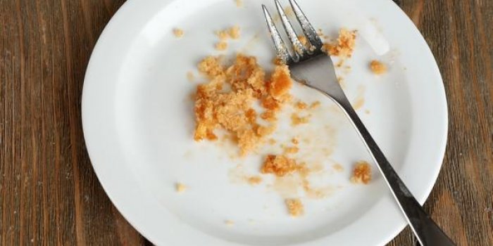 assiette vide sale avec une fourchette sur la table en bois