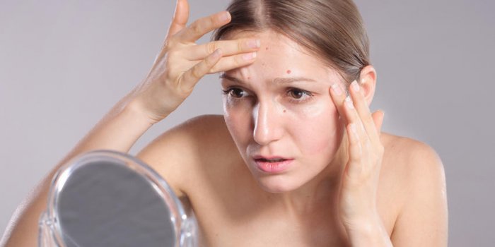 jeune femme presser son acné devant le concept de soins de la peau miroir femme