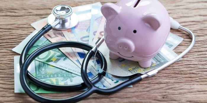 financial health check or eu economic concept, saving pink piggy bank with stethoscope on pile of euro banknotes on woode...