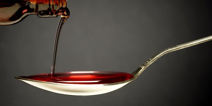 pouring cough syrup into a spoon
