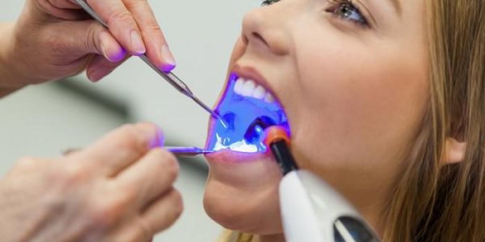 fermer de traiter le patient féminin avec un équipement dentaire pour la détermination de la couleur précise des dents