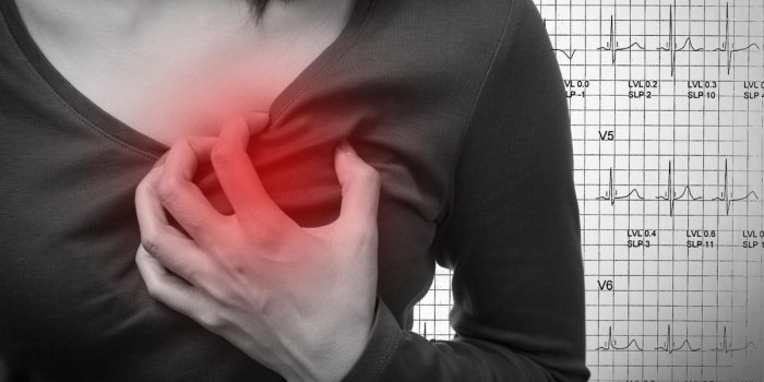 woman is clutching her chest, acute pain possible heart attack