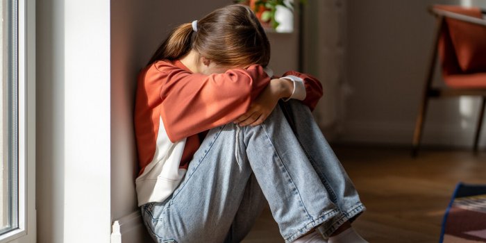 depression in teens upset teenage girl sitting alone on floor and crying, feeling sad and depressed lonely teenager child...