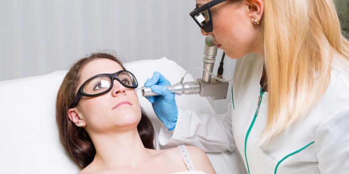 enlever la tache du foie du visage d'une jeune femme avec un laser médical