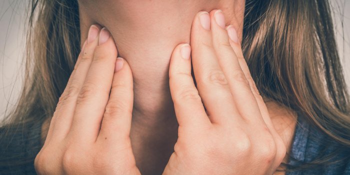 woman with throat sore is holding her aching throat - body pain concept