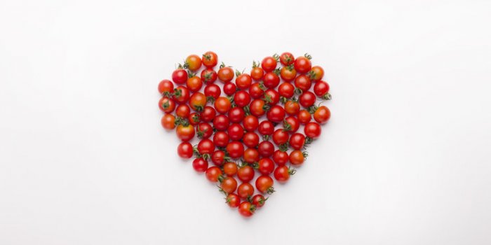 creative vegetarian concept heart shaped cherry tomatoes isolated on white panoramic background, copy space