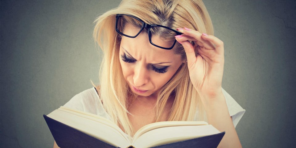 woman with glasses suffering from eyestrain after reading a book