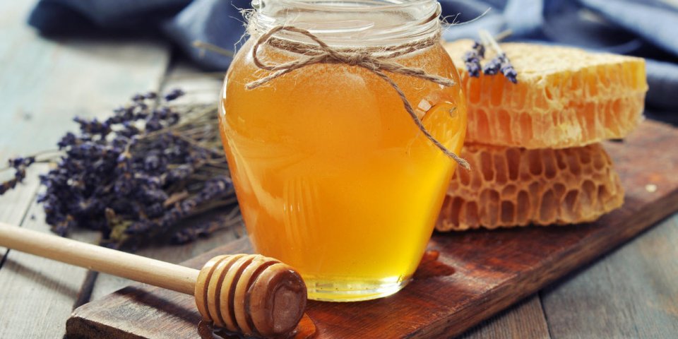miel en pot avec une louche de miel sur fond en bois vintage