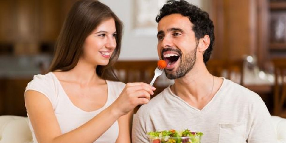 couple mangeant une salade dans le salon