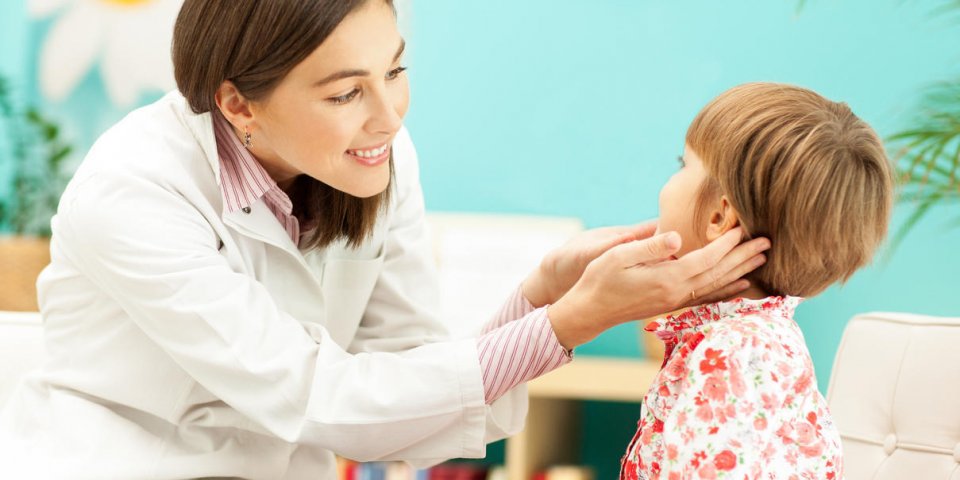 pédiatre souriant examinant une petite fille
