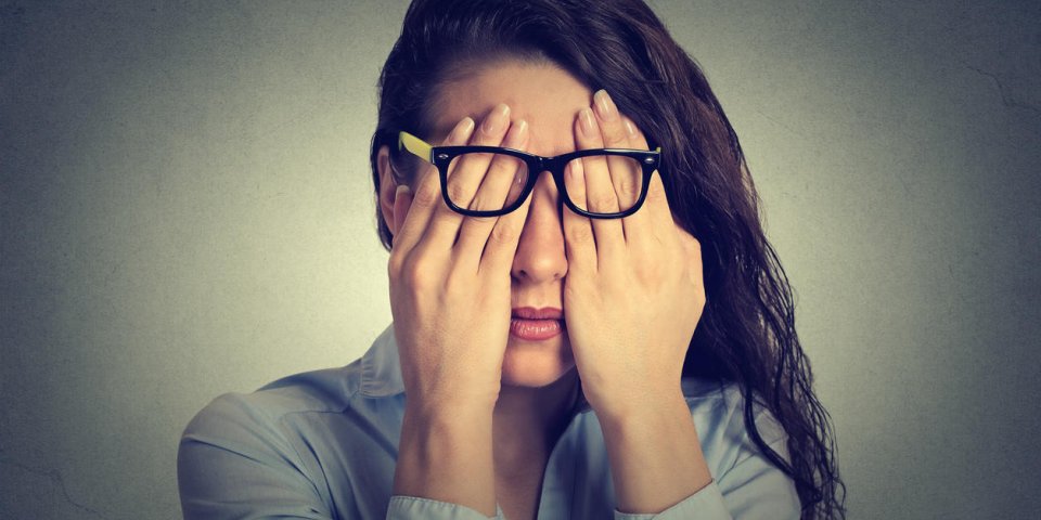 closeup portrait young woman in glasses covering face eyes using her both hands isolated on gray wall background