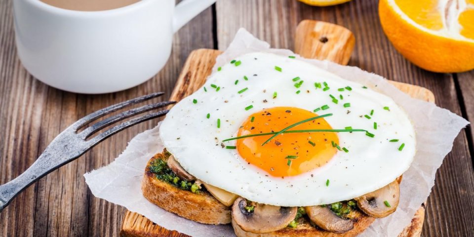 petit déjeuner oeuf au plat avec des champignons sur toast, orange et café