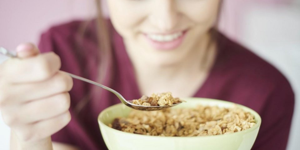 woman eating cereal in bowl