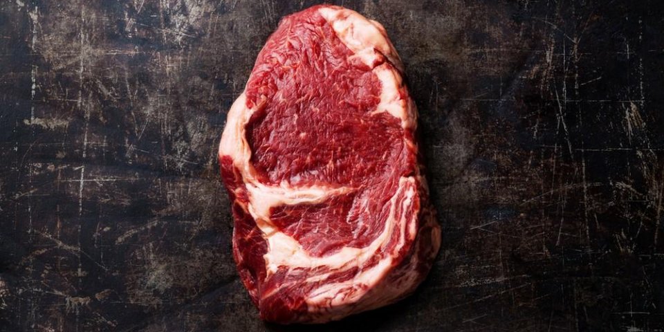 raw fresh meat ribeye steak on dark metal background