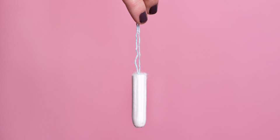 woman's hand holding a clean cotton tampon