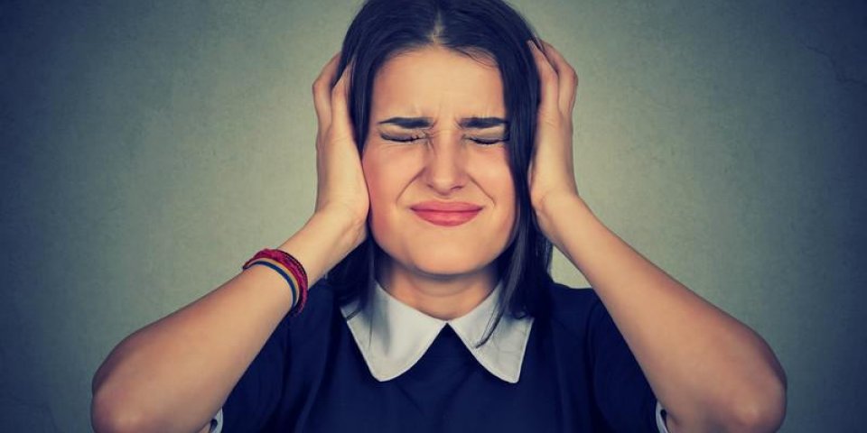 femme frustrée stressée couvrant ses oreilles avec les mains isolées fond gris négative réaction de l'émotion humai...