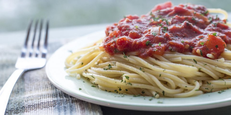 spaghetti and home made tomato sauce on green plate