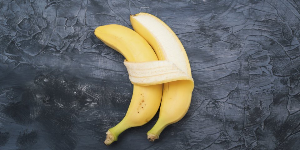two bananas isolated on dark background concept of embracing couple in love and tenderness
