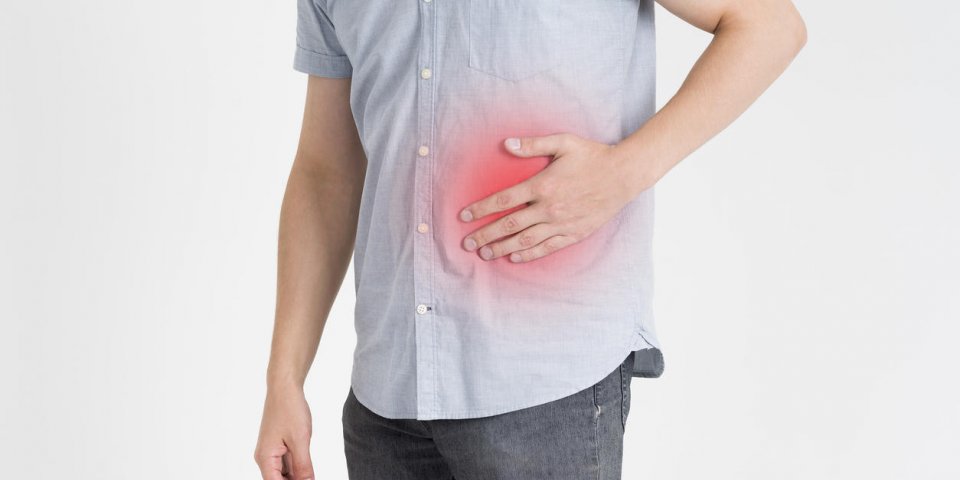 man with abdominal pain, stomach ache on gray background, studio shot with red spots